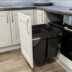 an empty dishwasher in a kitchen with white cabinets and gray counter tops,