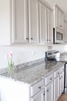 a kitchen with white cabinets and granite counter tops