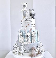 a three tiered cake with white frosting and animals on it's sides