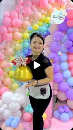 a woman holding a bell in front of balloons