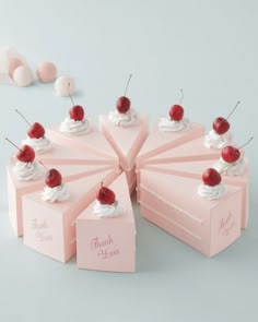 there are many pink boxes with cherry toppings on them