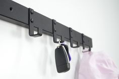 there is a car key hanging on the wall next to a pair of keys and a bag