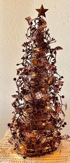 a christmas tree made out of wire and other items on top of a doily