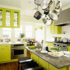 a large kitchen with green cabinets and white counter tops, an island in the middle