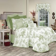 a bed room with a neatly made bed and green comforter on top of it