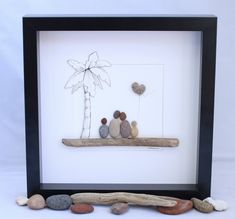 some rocks and a palm tree in a black shadow box on a white background,