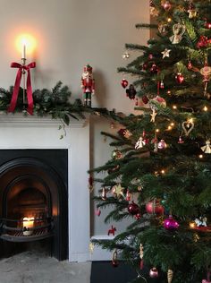 a decorated christmas tree in front of a fireplace