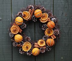 an orange wreath with cinnamons and pine cones