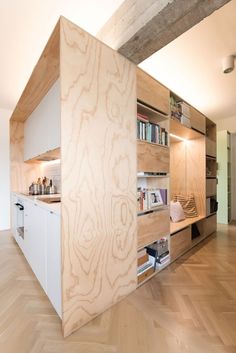 a kitchen with wooden floors and cabinets in the middle of an open floor plan area