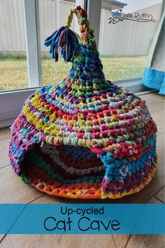 a multicolored basket sitting on the floor in front of a window