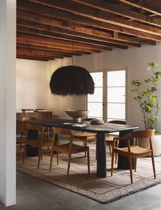 a dining room table with chairs and an umbrella hanging from the ceiling