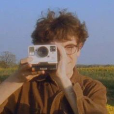 a man holding up a camera in front of his face