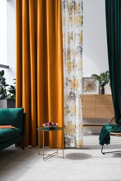 a living room with green velvet curtains and gold drapes on the windowsills