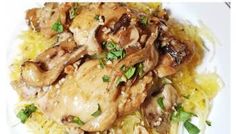 a white plate topped with chicken and mushrooms covered in sauce on top of yellow rice