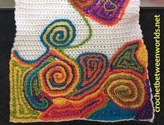 a crocheted square with colorful swirls on it