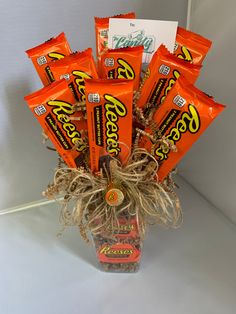 an arrangement of candy bars in a glass vase