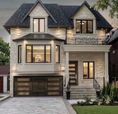 a two story house with an attached garage and stairs leading up to the front door