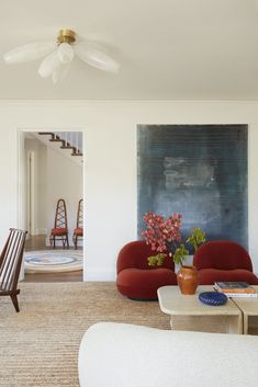 a living room filled with furniture and a painting on the wall