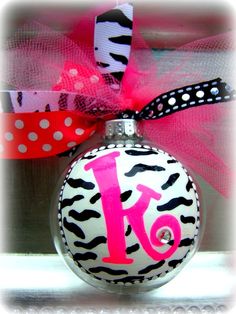 a christmas ornament decorated with zebra print and pink ribbon