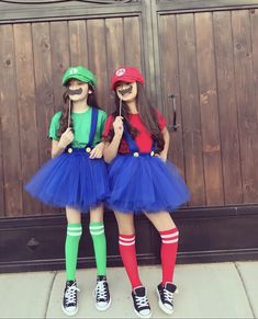 two girls dressed in costumes standing next to each other