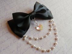 a black bow with pearls and a necklace