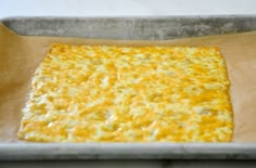 an uncooked cheese pizza sitting on top of a baking sheet in a pan