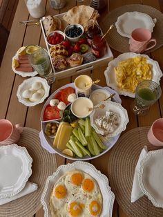 a table topped with plates and bowls filled with different types of breakfast foods on top of it