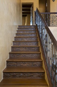 the stairs are made of wood and wrought iron railings, along with handrails