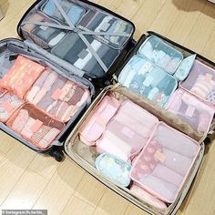 two suitcases filled with baby blankets and diapers on top of a wooden floor