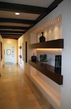 an empty hallway with shelves and vases on the wall