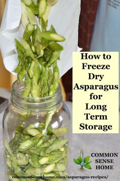 a jar filled with green asparagus sitting on top of a counter next to a paper towel