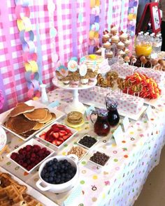 a table topped with waffles, fruit and other foods