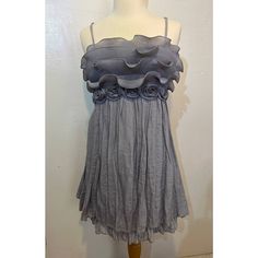 Mini Dress In A Light Blue/Grey Ish Color. Bottom Is A Gauzelike Fabric With A Second Slip Layer Underneath. Top Has A Chiffon Type Ruffles With Fabric Roses Under. Back Is Stretchy, Adjustable Straps. Fits S/M. Never Worn. Gray Sleeveless Ruffled Dress, Sleeveless Gray Dress With Ruffles, Gray Sleeveless Dress With Ruffles, Gray Mini Length Summer Dress, Gray Summer Party Dress, Gray Ruffled Mini Dress, Gray Mini Dress With Ruffles, Gray Flowy Summer Dresses, Summer Flowy Gray Dresses