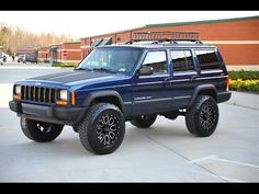 a blue jeep parked in front of a building