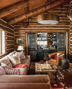 a living room filled with furniture and wooden walls