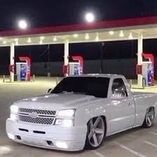 a silver truck parked in front of a gas station