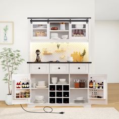 a kitchen with white cabinets and shelves filled with dishes on top of each shelf, next to a small potted plant