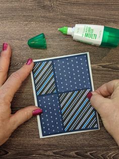 a woman's hands with red nail polish on top of a piece of paper