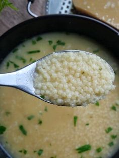 a spoon full of soup with rice and parsley