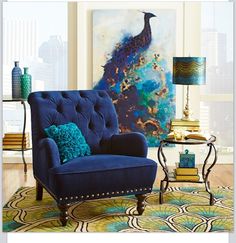 an open magazine with a blue chair and peacock painting on the wall next to it