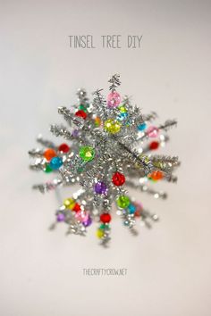 a snowflake made out of colored stones with the words tinsel tree diy on it