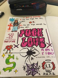 a notebook with stickers on it sitting next to a pen and some other items