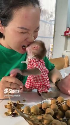 a woman holding a baby in her arms and eating something out of it's mouth