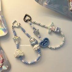 a white and blue beaded necklace with charms on it next to other items in the bag