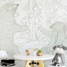 a white table and two chairs in front of a wall with an animal mural on it