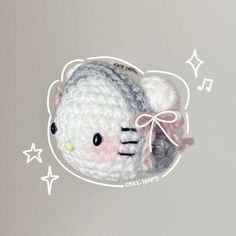 a crocheted hello kitty brooch sitting on top of a white table next to stars