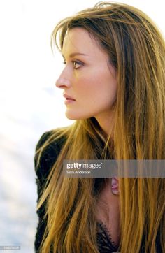 a beautiful young woman with long hair looking off into the distance stock - fotor