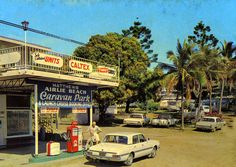 an old time gas station with cars parked in front