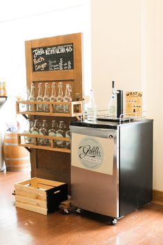 a small refrigerator sitting on top of a hard wood floor next to a wine rack