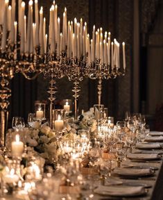 a long table is set with candles and flowers for an elegant dinner or reception party